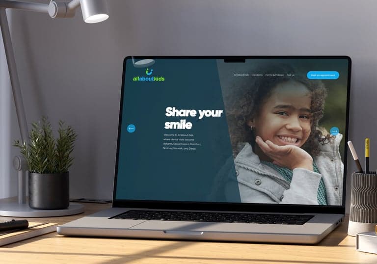 Website design on a laptop mockup: the All About Kids dental practice.