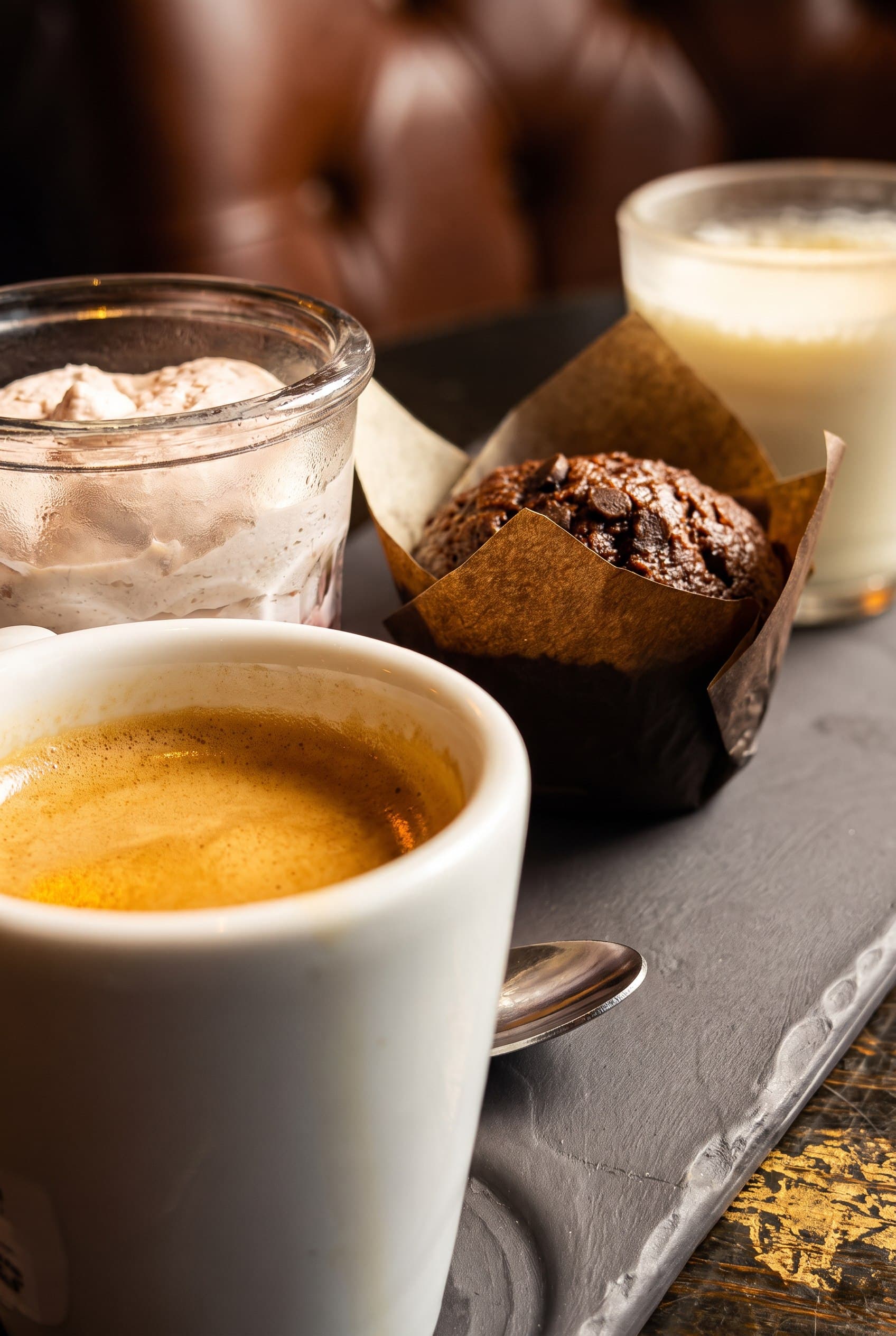 Close campaign view of espresso, cream dessert, chocolate muffin, and pale drink